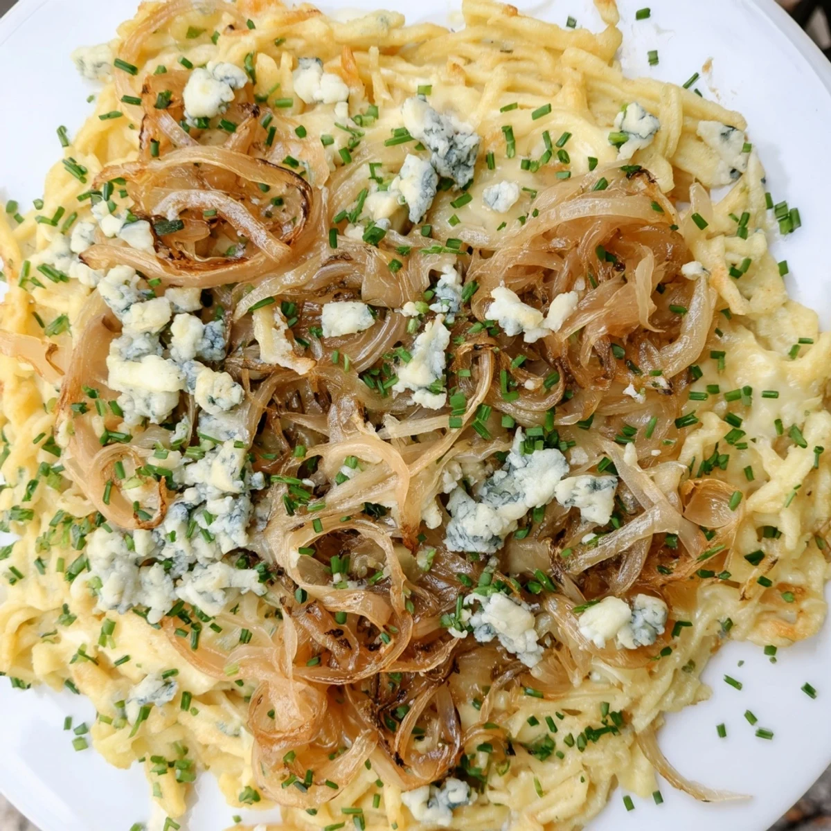 Golden, bubbling Käse-Spätzle Luxus with Gruyère cheese and toppings, a satisfying main course.