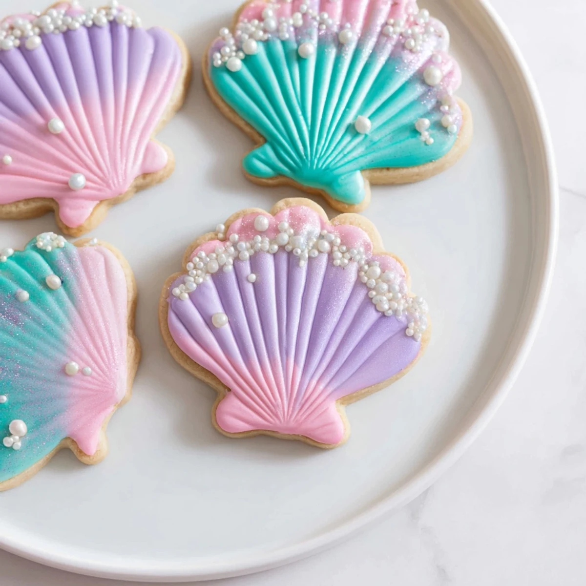 Freshly baked Seashell Sweets: whimsical sugar cookies with shimmering pastel icing for a delightful treat.