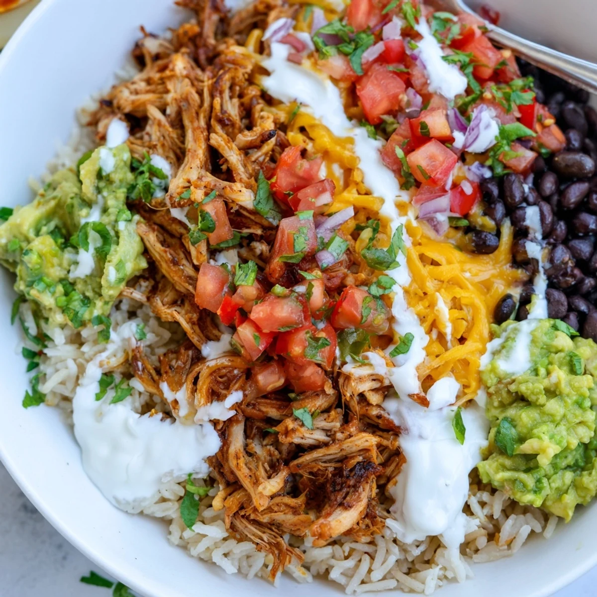 A vibrant Chipotle burrito bowl, loaded with savory carnitas and fresh guacamole.