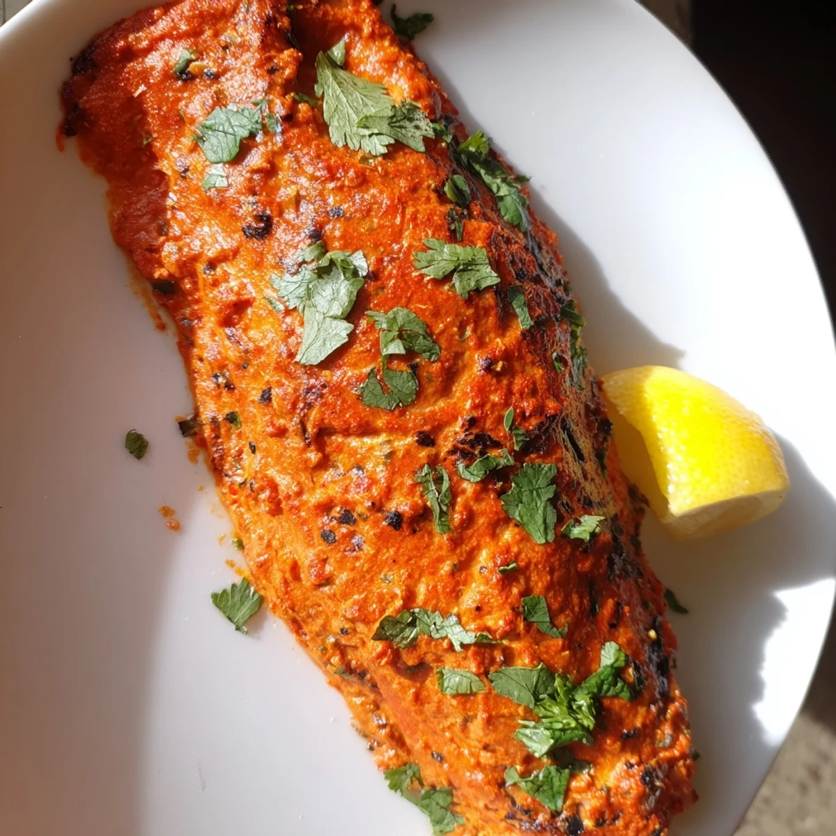 Crispy-edged Indian Tikka Salmon served with fresh cilantro and a squeeze of lemon.