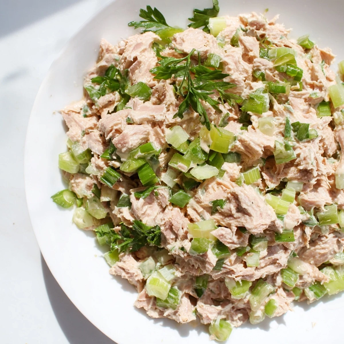 Close-up of vibrant Spicy Zesty Tuna Salad with fluffy flakes and crisp scallions.
