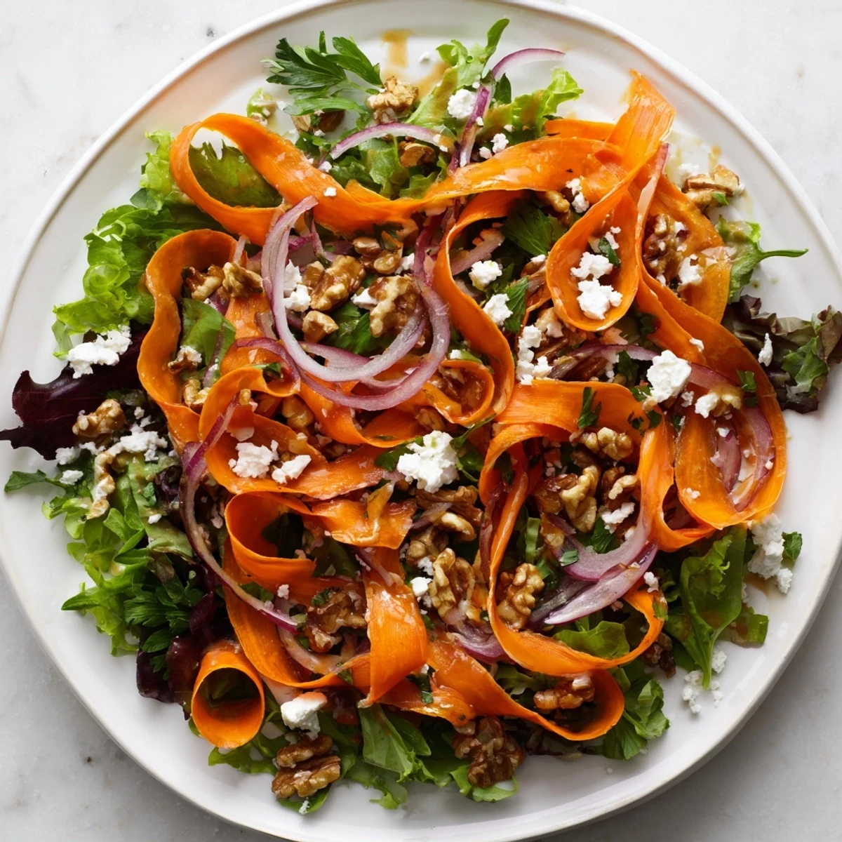 Knusprige geröstete Karottenstreifen auf Babyspinat und Rucola, angerichtet mit Honig-Senf-Dressing und gehackten Kräutern.