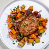 Tender pork chops and roasted root vegetables on a sheet pan; easy Sheet Pan Pork Chop recipe.