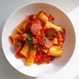 Close-up of bubbling Spanish chorizo pasta, a flavorful main dish with tomatoes and spices.