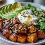 Hot Honey Sweet Potato Bowl mit cremiger Avocado und scharf-süßem Honig Dip auftellend serviert