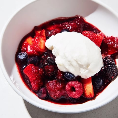 Vibrante Beerenkompott mit Sahne, perfekt als Dessert oder Topping.