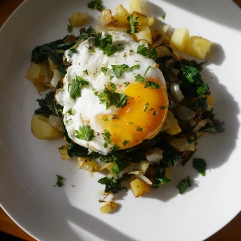 Golden, crispy Spinach and Potato Skillet, topped with a runny fried egg ready to eat.
