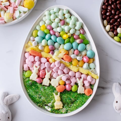 Festive egg-shaped candy platter overflowing with colorful treats perfect for an Easter celebration.