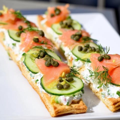 Festlich angerichtete Étoiles Filantes Assiette de Fin dAnnée: goldbraune Blätterteigsterne mit Rauchlachs.