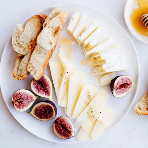 French Bistro Elegance platter with artisan baguettes, Brie, Comté, Chèvre cheese, and figs.