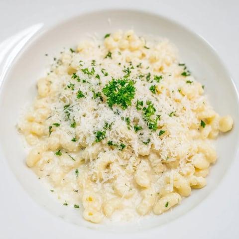 Steaming bowl of 15-Minute Garlic Parmesan Pasta, glistening with creamy garlic sauce and fresh parsley garnish.