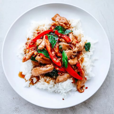 Tender Thai Basil Chicken Bowls, stir-fried with peppers and herbs, ready to serve over rice.