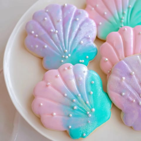 Enjoy these beautiful seashell sweets, decorated with pastel icing and sparkling edible pearls.