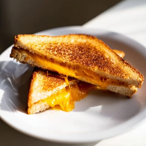 A close-up of a perfectly browned mayo grilled cheese sandwich, oozing with melted cheese and ready to eat.