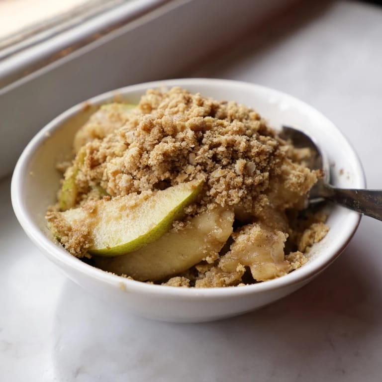 Aromatisches Apfel-Zimt-Crumble, frisch aus dem Ofen, ideal für kühle Abende.