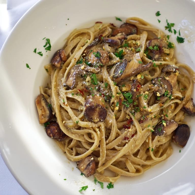 Warm plate of Pasta Aglio e Olio with Mushrooms, perfectly seasoned, ready for a delicious dinner.