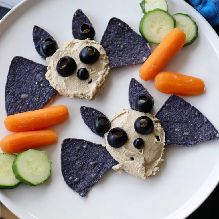 Creamy black bean dip transforms into spooky bat shapes on this festive appetizer platter.